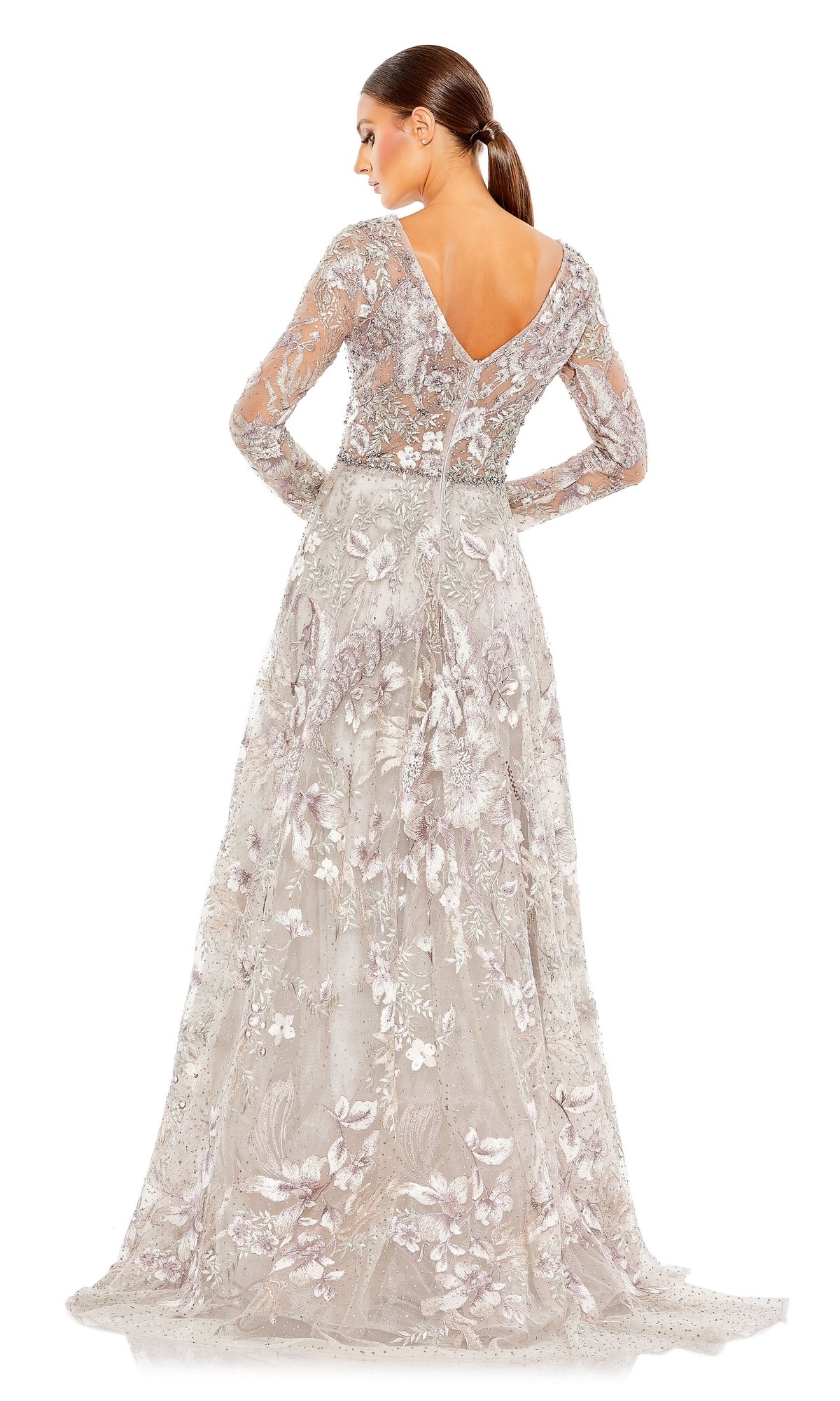 A woman is seen from the back wearing the Mac Duggal 20214 Long Sleeve Long Formal Dress—a floor-length silver gown featuring floral embroidery and sheer details.